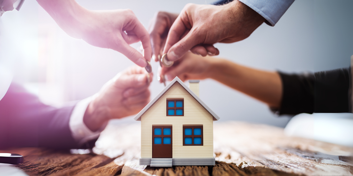 Build your dream team for fix-and-flip housing. Four team member hands reaching towards a common home. 