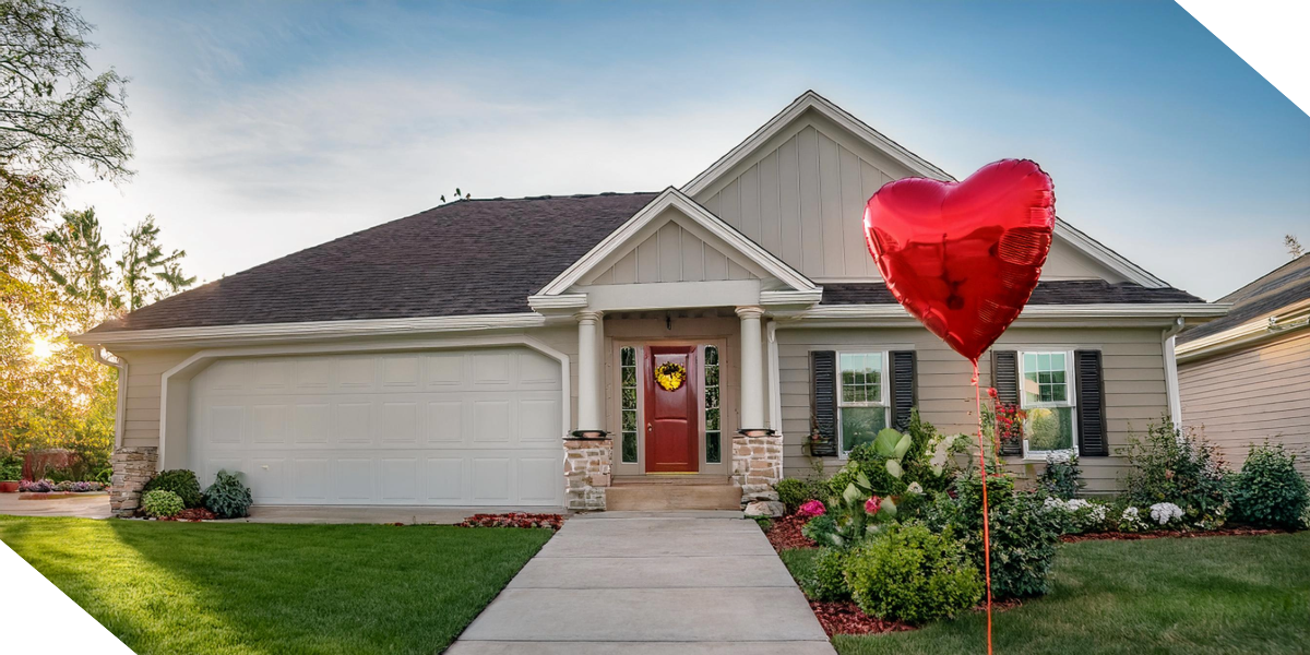 Suburban home with a red heart balloon, symbolizing love for real estate investing with Kiavi.